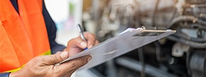 picture of an inspector marking paper on a clipboard